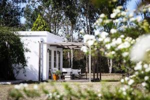 El Encón芬卡瓦伦蒂娜酒店的白色的房子,设有野餐桌和庭院