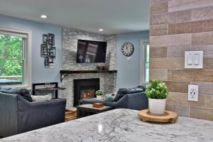 ein Wohnzimmer mit Sofas und Kamin in der Unterkunft Fun In Fun Out Ski Home - Upper Unit, Renovated 3BR-2BA, Hot Tub, Close to Resort in Killington