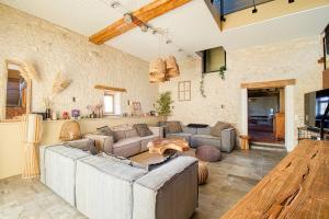 a living room with a large couch and a table at Magnifique maison de campagne aux portes de Sancerre, by Rurals in Gardefort