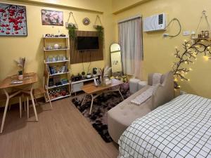 a bedroom with a bed and a table and a desk at SyHOME-Suites in Trece Martires