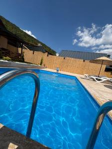 a large blue swimming pool in front of a house at Uysal Dağevleri in Bilecik +6 photos