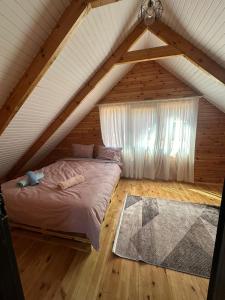 a attic bedroom with a bed and a window at Uysal Dağevleri in Bilecik