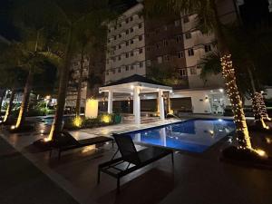 a swimming pool in front of a building at night at SyHOME-Suites in Trece Martires +7 photos