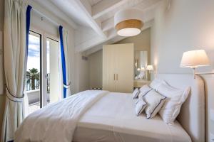 ピエトラ・リーグレにあるA'mare Boutique Hotel & Spaの大きなベッドと窓のある白い寝室