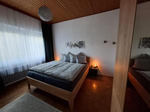 a bedroom with a bed and a large window at Ferienwohnung Heiabett in Wies