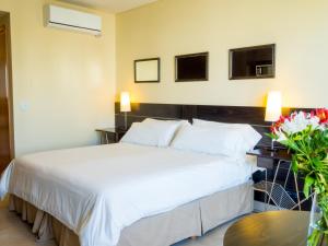 a hotel room with a bed and a table with flowers at Two Independent Palermo Hollywood Studios at Buenos Aires's Best Neighborhood in Buenos Aires