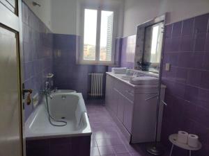 a bathroom with a tub and a sink and a bath tub at Appartamento incantevole con loggia sui tetti in Siena +28 photos