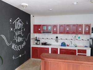 a kitchen with red cabinets and a chalkboard on the wall at Hola! Veci in Villa de Leyva