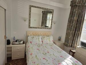 a bedroom with a bed and a mirror on the wall at Shoreline Accommodation in Bournemouth