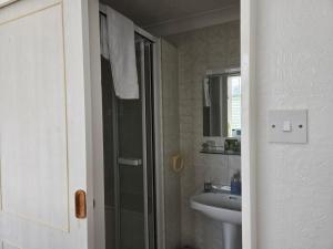 a bathroom with a sink and a shower and a mirror at Shoreline Accommodation in Bournemouth