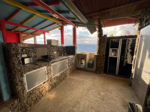 a kitchen with a stove and a stone wall at Cabaña Parque Arvi vista panorámica in Medellín