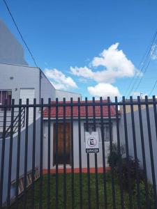蓬塔格罗萨Casa central 74 com ótima localização的房屋前有标志的栅栏