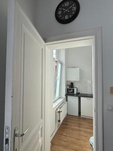 a clock on a wall above a kitchen at Studio Nahida in Brussels