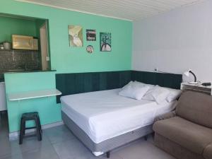 蓬塔格罗萨Casa central 74 com ótima localização的卧室里有一张床和一张沙发
