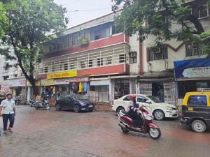 a person riding a scooter on a city street at Ram niwas hotel in Mumbai