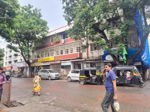 a man walking down a city street talking on a cell phone at Ram niwas hotel in Mumbai