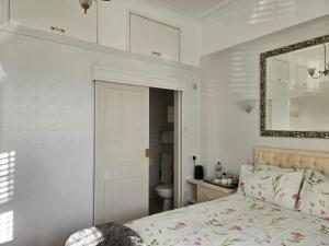 a bedroom with a bed and a mirror and a sink at Shoreline Accommodation in Bournemouth