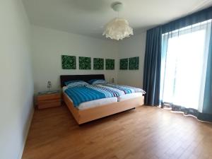 ein Schlafzimmer mit einem Bett und einem großen Fenster in der Unterkunft Refugium Prerow in Prerow