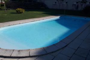 a swimming pool with blue water in a yard at Sweet Ericeira Surf, Apartment in Ericeira