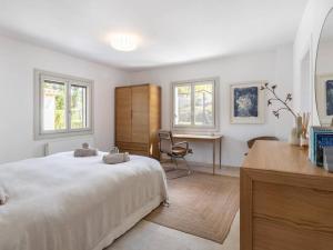 a white bedroom with a bed and a desk at Villa La Telaranya - Luxury villa with heated pool close to Port Pollença in Port de Pollensa +50 photos