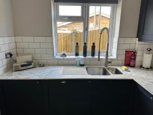 a kitchen counter with a sink and a window at The Beach Hut in Seasalter +23 photos