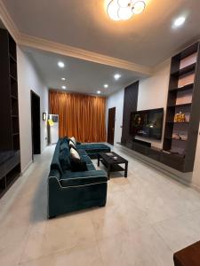 a living room with a black couch and a tv at Space Luxury Apartments in Lagos