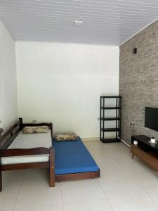 een kamer met een bed en een tv erin bij Cantinho da serra in Ubatuba