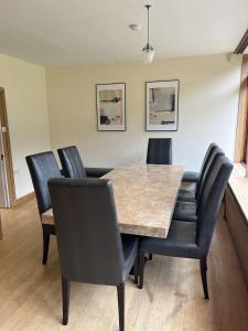 オックスフォードにあるSpacious and stylish with games room, huge garden, peaceful surroundingsのダイニングルーム(テーブル、黒い椅子付)