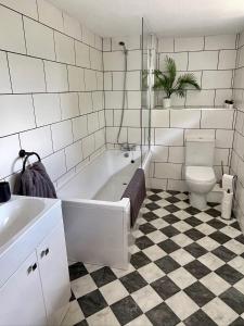 オックスフォードにあるSpacious and stylish with games room, huge garden, peaceful surroundingsの浴槽、トイレ、洗面台を備えたバスルーム +15枚の写真