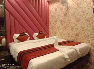 a bedroom with a bed with a red headboard at Hotel Ganpati in Patna +2 photos