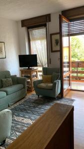 un salon avec deux canapés et une télévision dans l'établissement Cottage Deluxe - nel cuore di Asiago, à Asiago