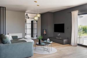 a living room with a couch and a tv at Villa Bewegte Berge in Kaštelir