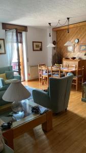 un salon avec un canapé et une salle à manger dans l'établissement Cottage Deluxe - nel cuore di Asiago, à Asiago