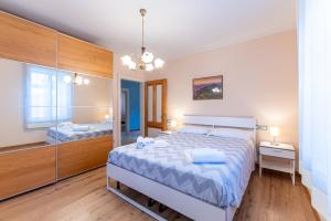a bedroom with two beds and a mirror at Cedolini House in Ovaro