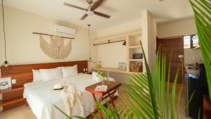 a bedroom with a white bed and a table at Shankara Holbox in Holbox Island