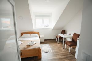 a small room with a bed and a table at Apartmani Davidović in Arilje