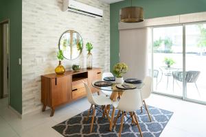 马萨特兰Departamento Con Alberca的一间带桌子和白色椅子的餐厅