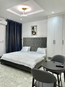 a bedroom with a bed and a table and chairs at Bilak Luxury Apartments & Homes Ltd in Abuja