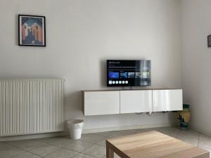 ピアチェンツァにあるPiacenza City House Gardenのリビングルーム(白いキャビネット、テレビ付)