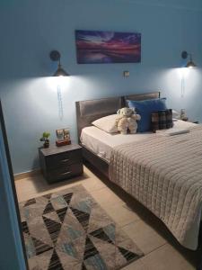 a bedroom with a bed with a teddy bear on it at Piraeus Seaside Apartment Escape in Piraeus