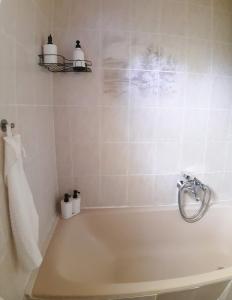 a bathroom with a bath tub with a towel at Sunshine Vendégház Balatonfenyves in Balatonfenyves +39 photos