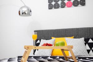 Una mesa de café con una bandeja de fruta y un vaso de jugo de naranja. en H4 Art Sparta Apartment, en Esparta 25 fotos más