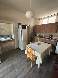 a kitchen with a table and a refrigerator at Anna Vendégház in Kápolnásnyék