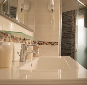 a bathroom with a sink and a phone on the wall at Casa Corona in Capoterra