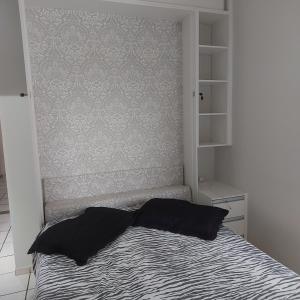 a bed with two pillows on it in a bedroom at Apartamento Praia do Morro em Guarapari in Guarapari