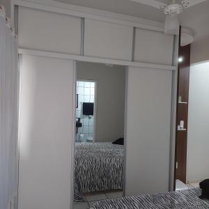 a bedroom with a bed and a large mirror at Apartamento Praia do Morro em Guarapari in Guarapari +3 photos