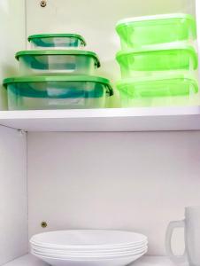 a white shelf with green vases on it at Apê Bela Vista com Piscina I Wi-Fi e A/C in Imperatriz