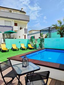 a patio with a table and chairs next to a swimming pool at Villa Paraíso da Caparica in Charneca