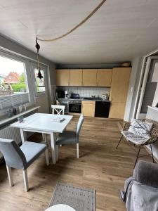 una cucina con un tavolo bianco e sedie in una stanza di Haus Inseltraum Whg 2 a Fehmarn Altre 3 foto