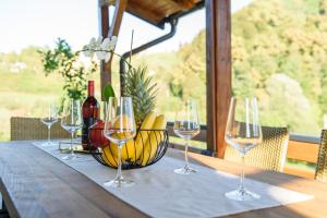 a table with wine glasses and a basket of bananas at Kuća za odmor MEDENA in Vižovlje